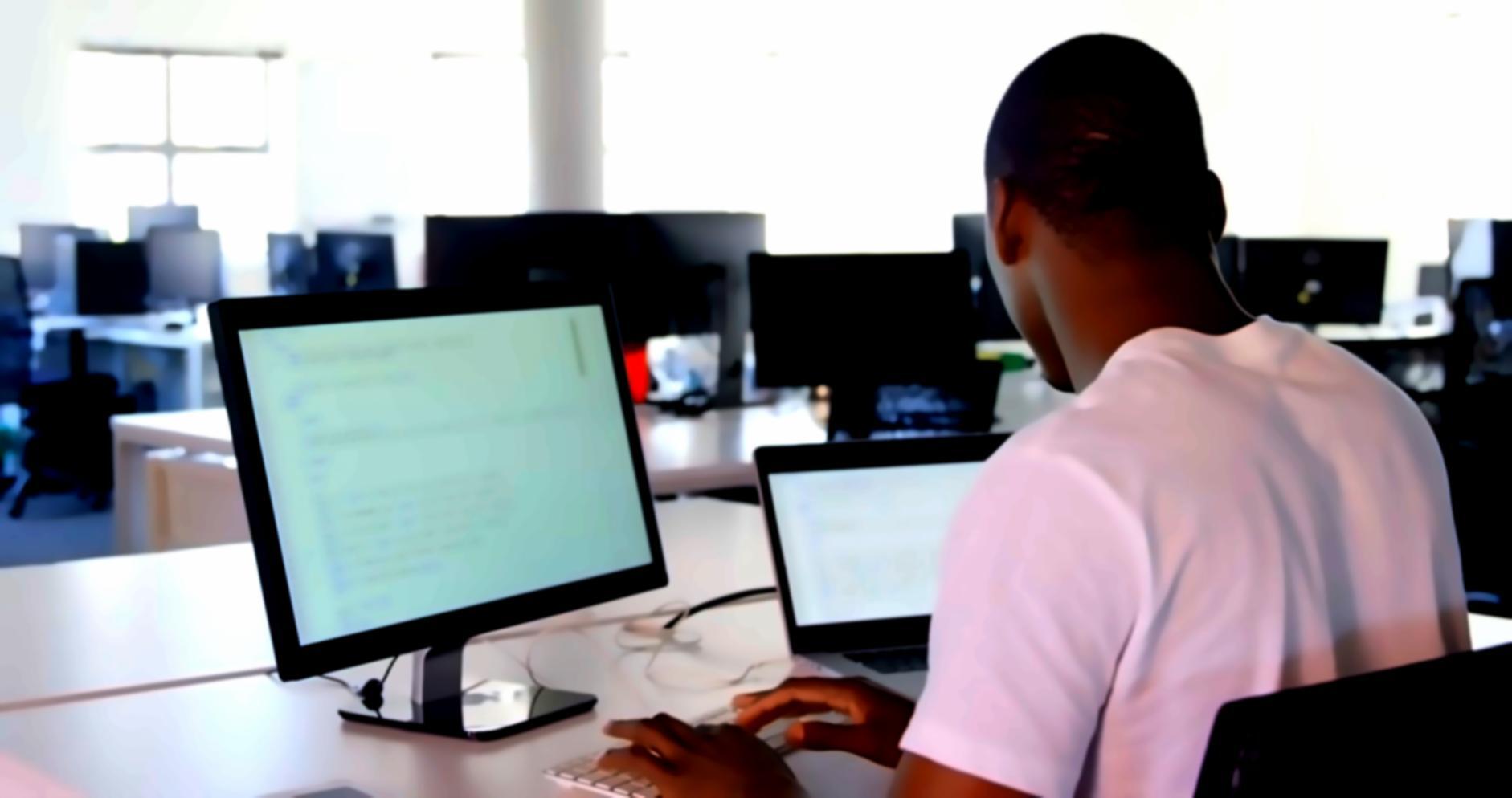 Professional software development workspace with multiple monitors showing system programming code